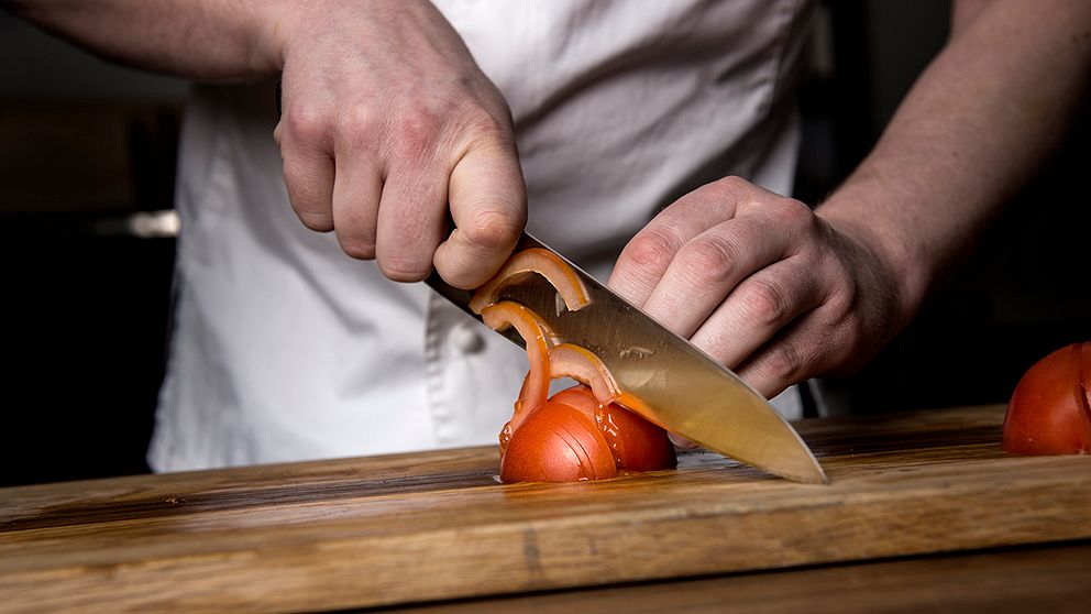 Kock skär tomater.