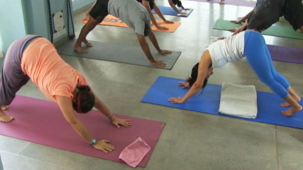 Personer som gör yoga i yogastudio.