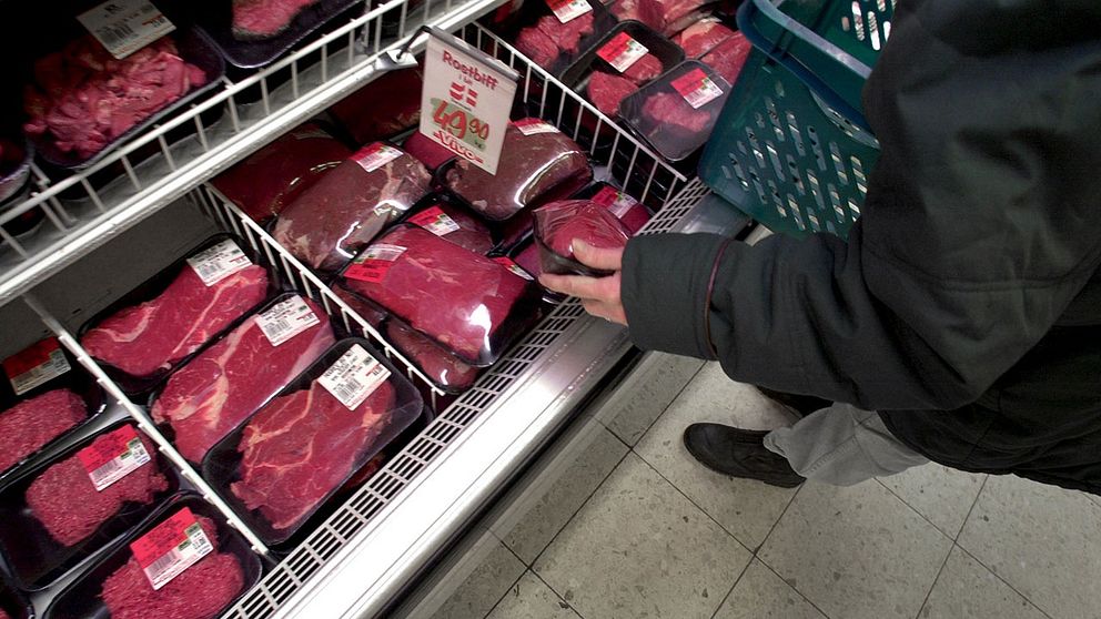 En person tittar efter kött i köttdisken.