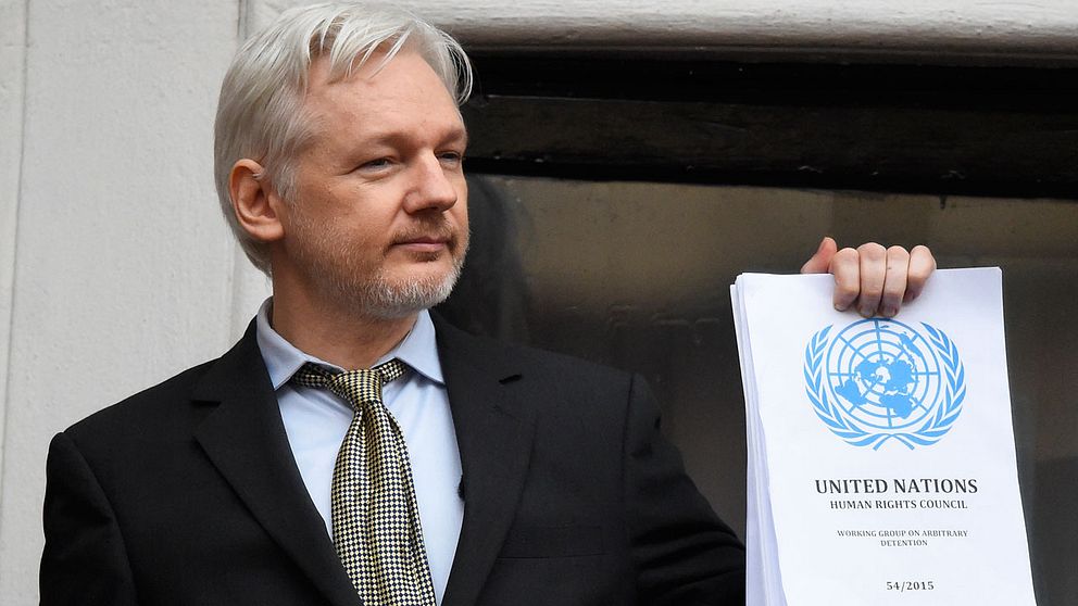 Julian Assange med FN-rapporten i sin hand.