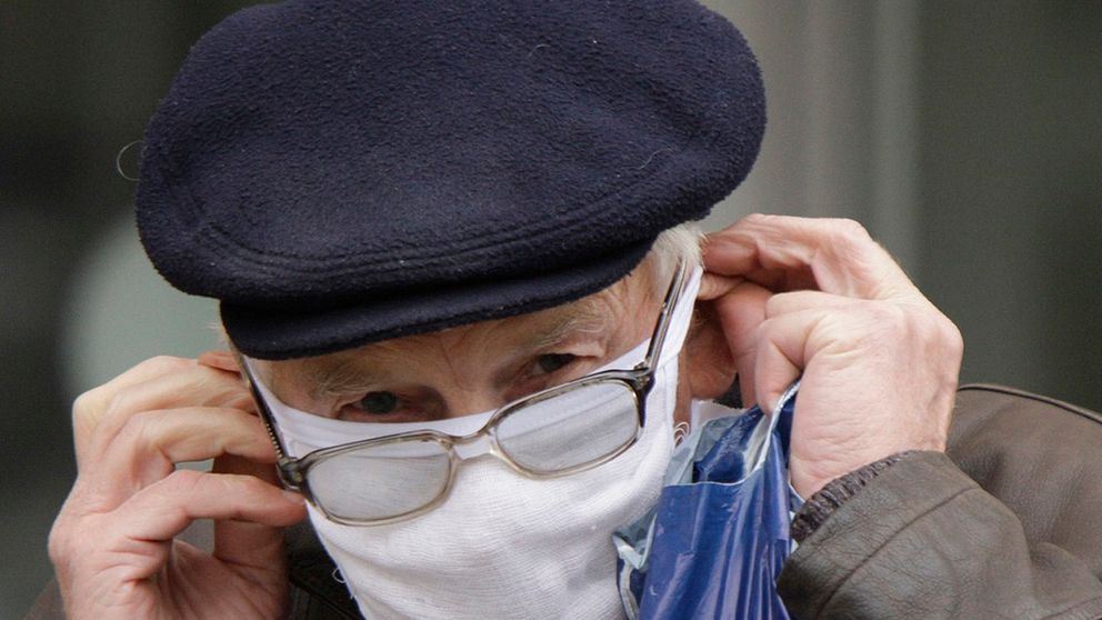 En man i Ukraina försöker undkomma influensa genom att använda munskydd.