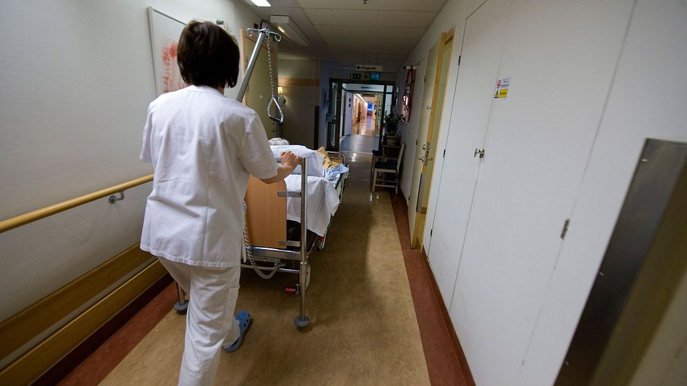 Sjuksköterska med säng i korridor