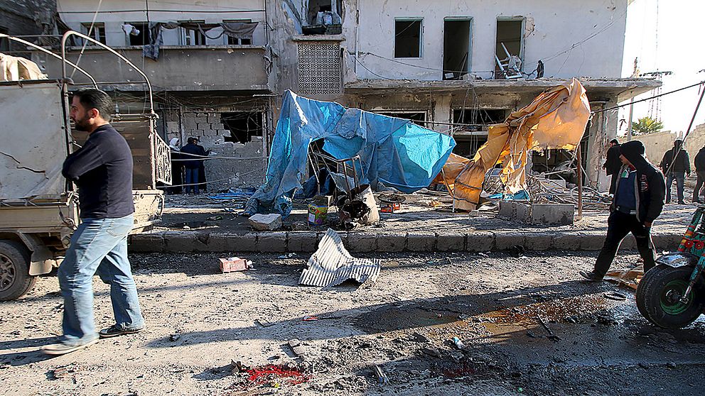 Invånare i Aleppo betraktar förödelsen efter luftangrepp den 8 februari.