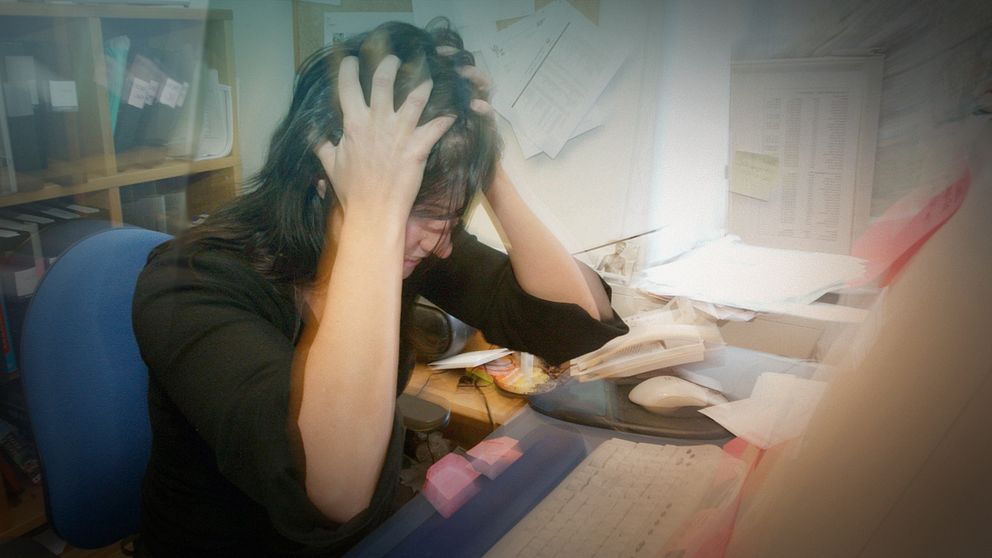 Stressad kvinna i kontorsmiljö