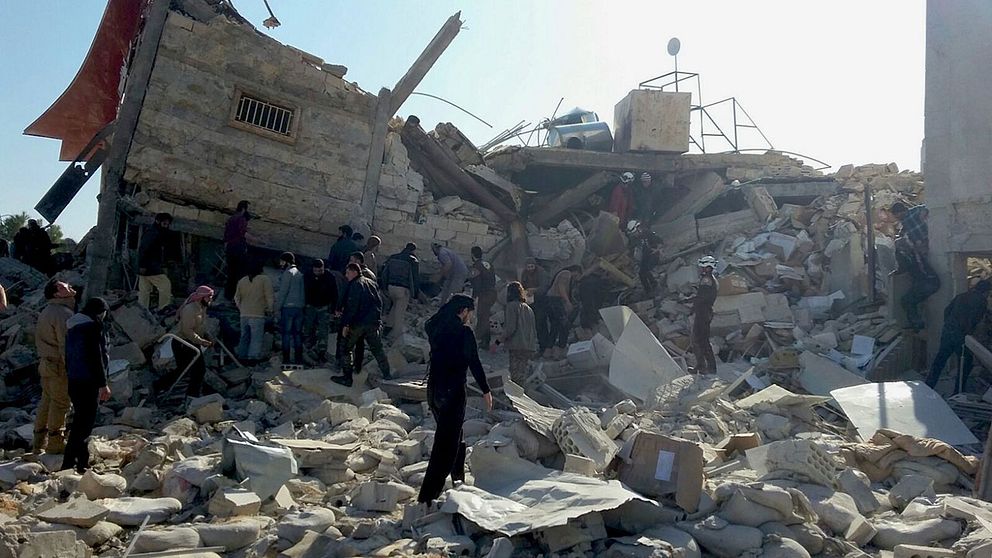 Människor letar igenom ruinerna av ett förstört sjukhus i Idlib-provinsen i Syrien.