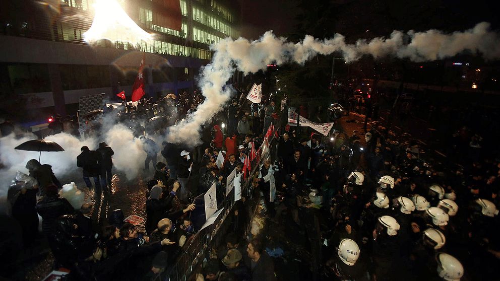 Poliser skjuter tårgas mot demonstranter utanför den turkiska tidningen tidigt på lördagsmorgonen.