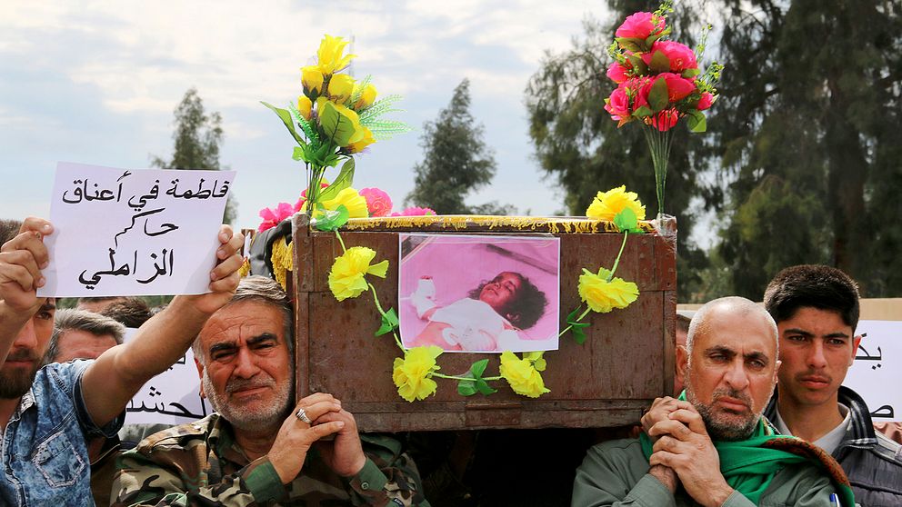 Sörjande bär fram kistan där den treåriga flickan placerats efter att hon dödats i en IS-attack.