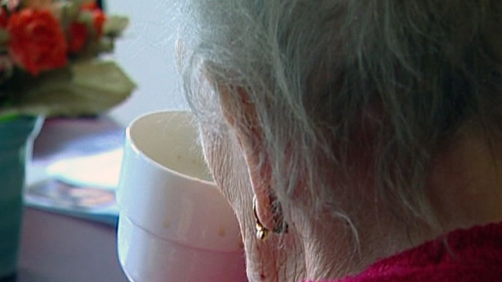 Äldre kvinna dricker kaffe