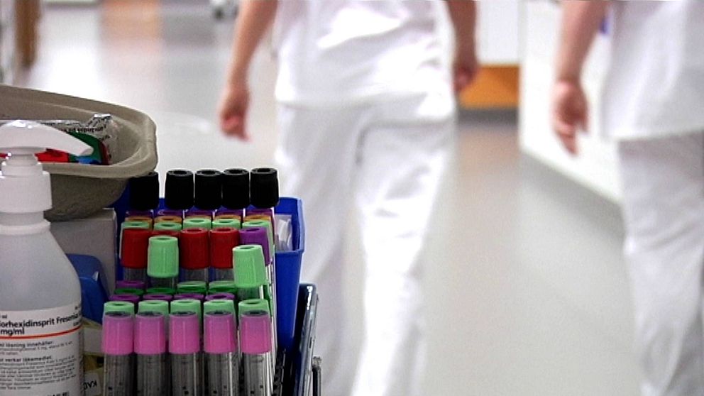 förgrund: blodprover. Ur fokus i bakgrund: personal i vita kläder