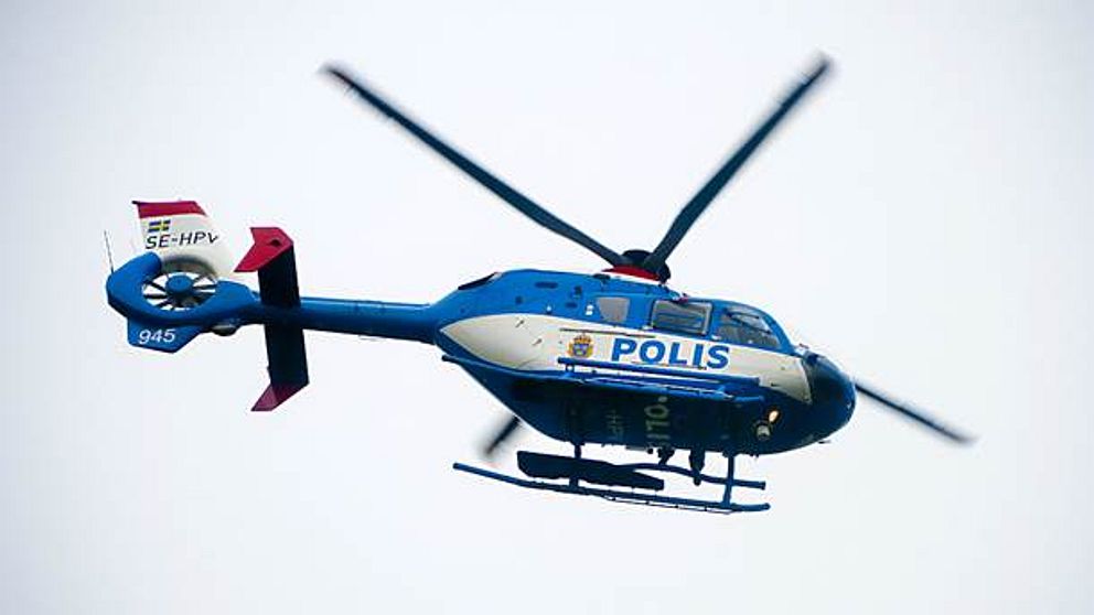 En polishelikopter som snurrar i luften