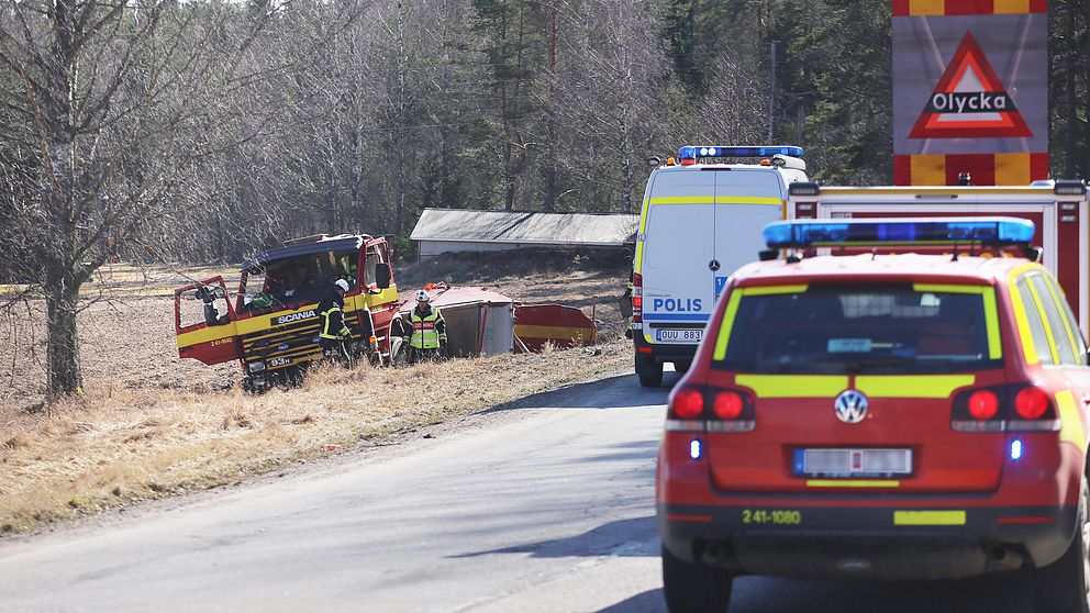 Brandbil i diket, räddningspersonal runt omkring.