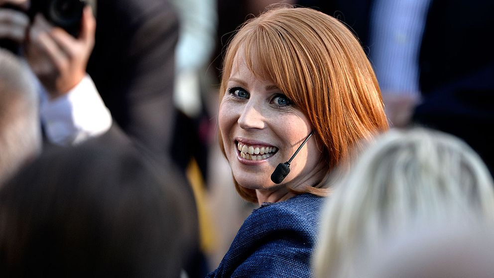 Annie Lööf som ler i en bland människor runtomkring.