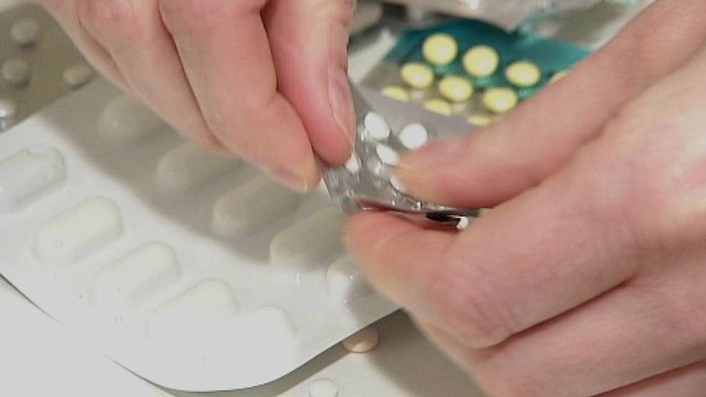 Hand som trycker ut tabletter från medicinkarta