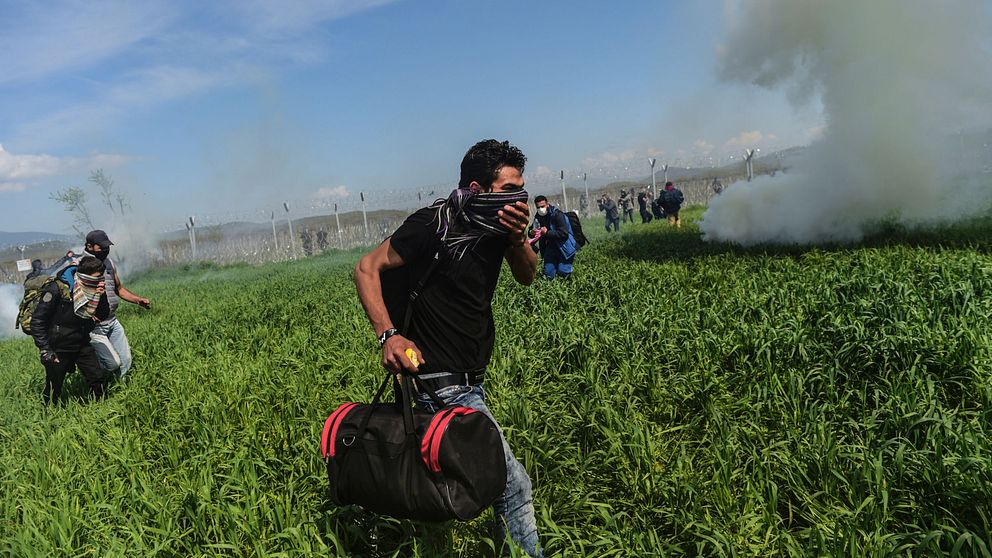 Den makedonska polisen kastar tårgas mot migranter och flyktingar.