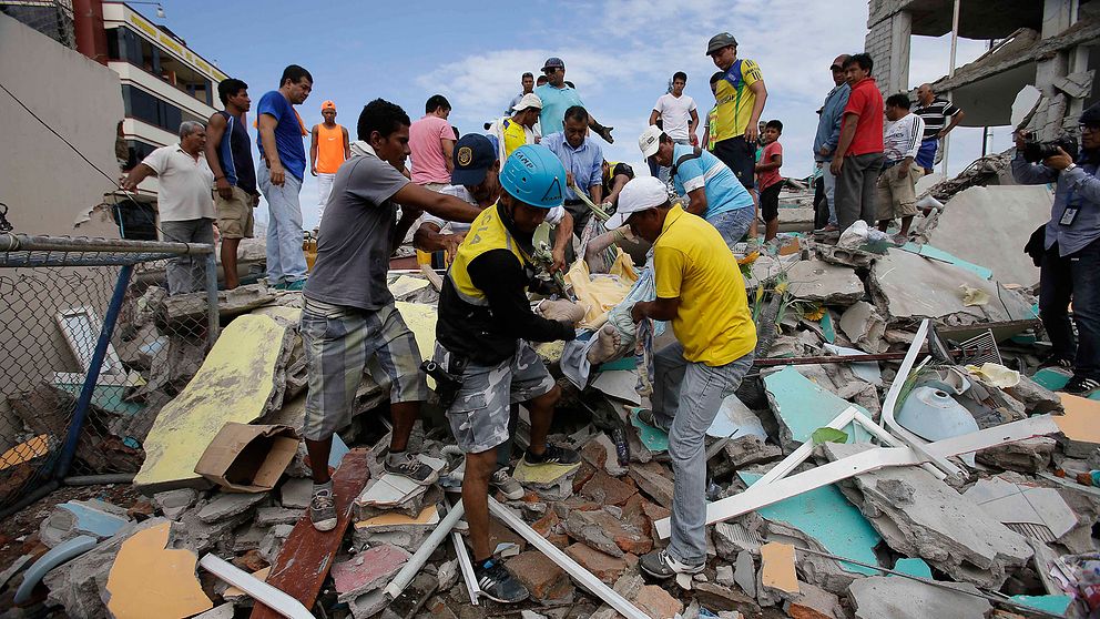 En skadad man dras fram från ett raserat hus i Ecuador