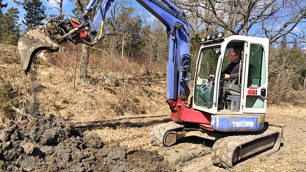 Håkan Carlsson gräver dike till avloppsanläggning på Barnens Ö med sin inhyrda minigrävare.