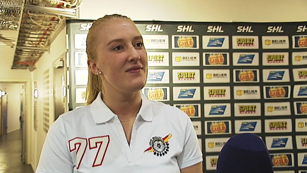 En ung kvinnlig hockeyspelare står och blir intervjuad.