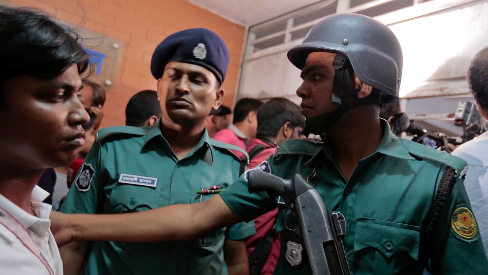 Bangladeshisk polis utanför lägenheten i Dhaka där två män mördats.