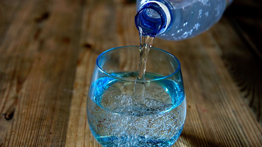 Vatten hälls från en flaska till ett glas.