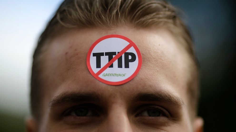 Greenpeaceaktivist med ett anti-TTIP-märke i pannan.