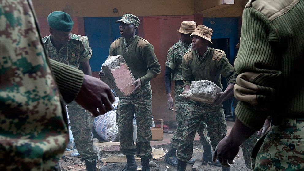 Räddningsarbetare lyfter bort bråte från rasmassorna i Nairobi.