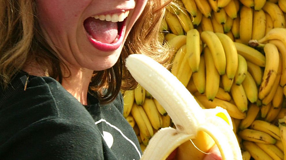 En kvinna äter banan.