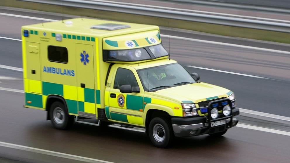 En ambulans som kör på en större väg.