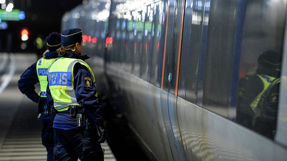 Poliser som står bredvid ett Öresundståg.