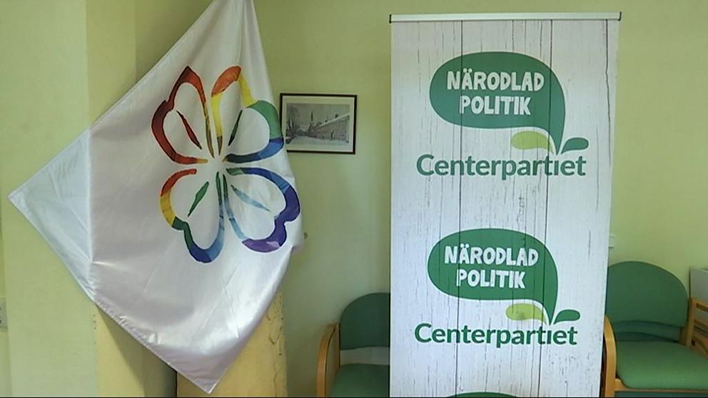Centerpartiet logotyp och en flagga med partiets klöver i regnbågsfärger