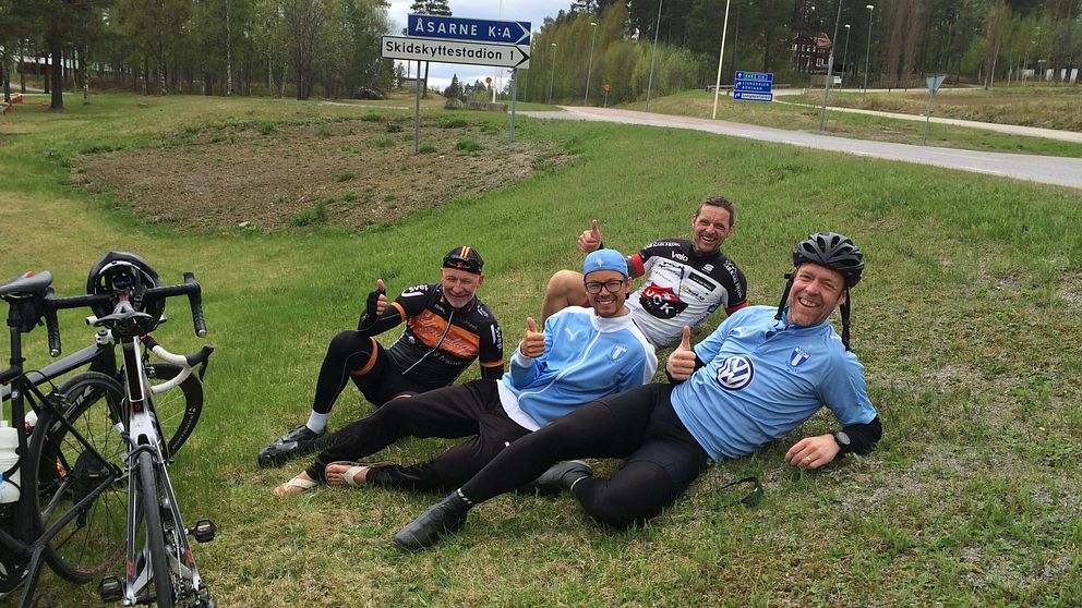 En bild på de MFF-supportrar som cylkar från Malmö till Östersund för att se fotbollsmatchen mellan ÖFK och MFF. Här vilar de i gräset i Åsarna.