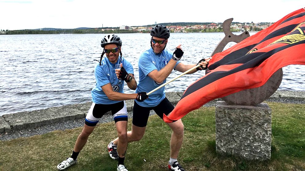 MFF:arna Daniel Håkansson och Michael Nilsson Pauli vinkar med ÖFK-flagga vid Storsjöns strand.