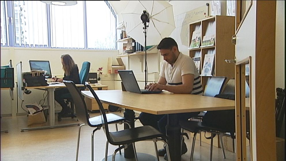 Hassan Nfeifeh sitter och skriver på en dator i ett kontorslandskap.