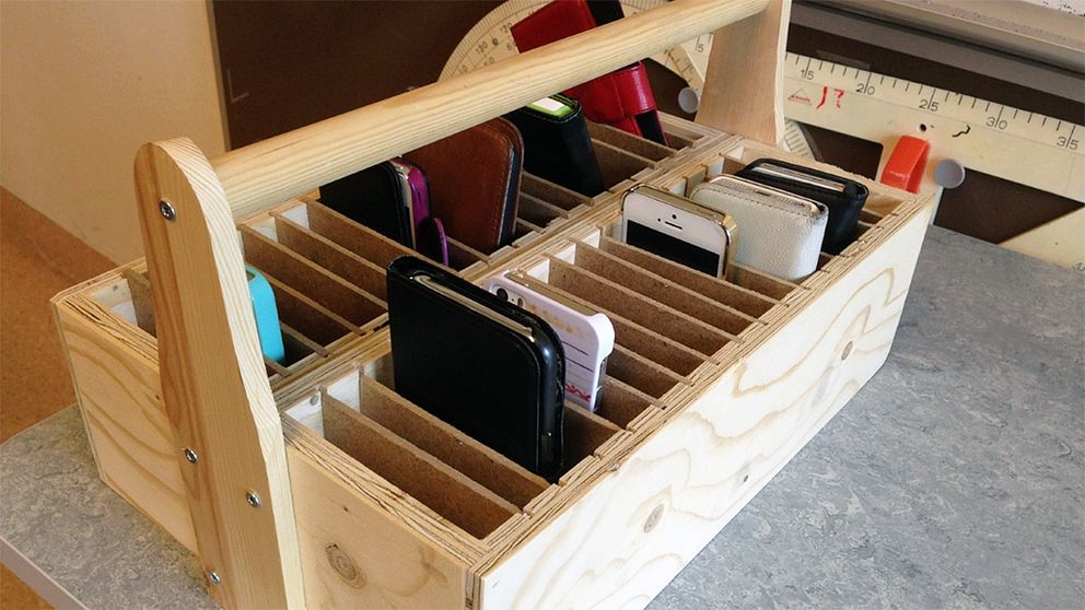 En låda med fack för mobiltelefoner i ett klassrum