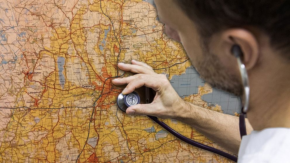 Läkare lyssnar med stetoskop på karta