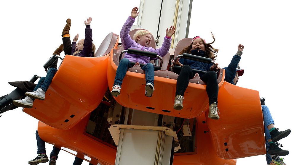 Barn som håller upp händerna när de åker en attraktion på Gröna Lund.