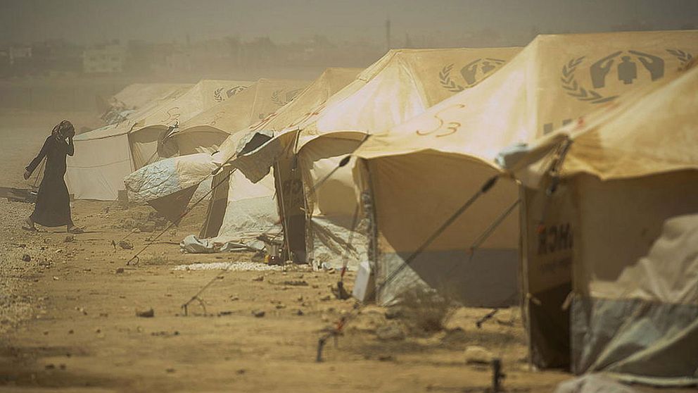 En kvinna går genom flyktinglägret Zaatari, i Jordanien. Väderförhållandena i lägret är svåra, med omväxlande kyla och hetta samt sandstormar.
