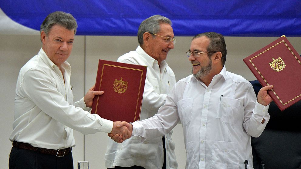 Colombias president Juan Manuel Santos och Farcgerillans ledare Timoléon Jiménez. I mitten Kubas president Raúl Castro.
