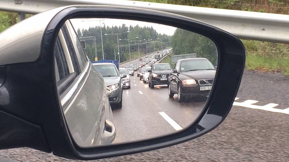 Bilköer sedda via sidospegel på bil.