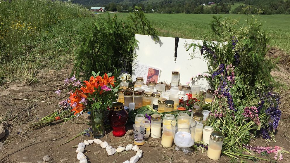 Blommor och tända ljus har lämnats vid olycksplatsen där en ung man omkom på midsommaraftonen.