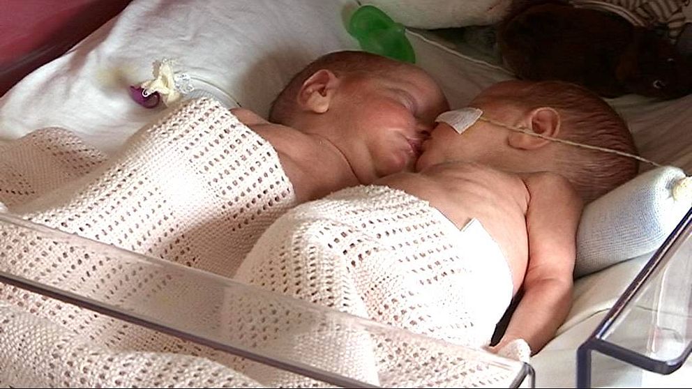 Två nyfödda barn i en sjukhussäng.