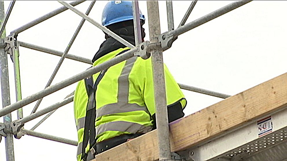 En byggnadsarbetare står på en byggarbetsplats.