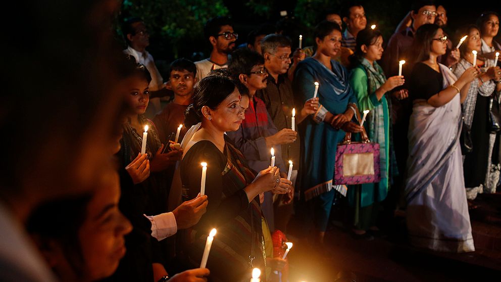 Invånare i Dhaka tänder ljus till minne för offren i massakern på en restaurang i helgen.