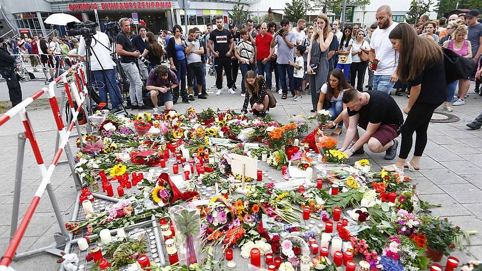 Människor lägger blommor framför shoppingcentrumet där fredagens skottdrama ägde rum.