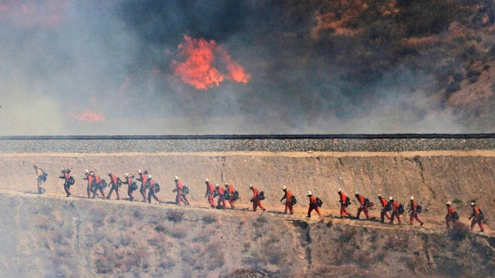 Brandmän närmar sig en mark- och skogsbrand i Santa Clarita i Kalifornien. Boende i hundratals hem har evakuerats.