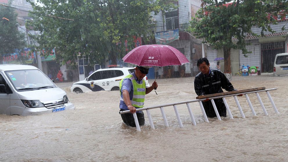 Två män på en översvämmad gata.