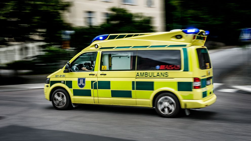 En ambulans kör på en gata.