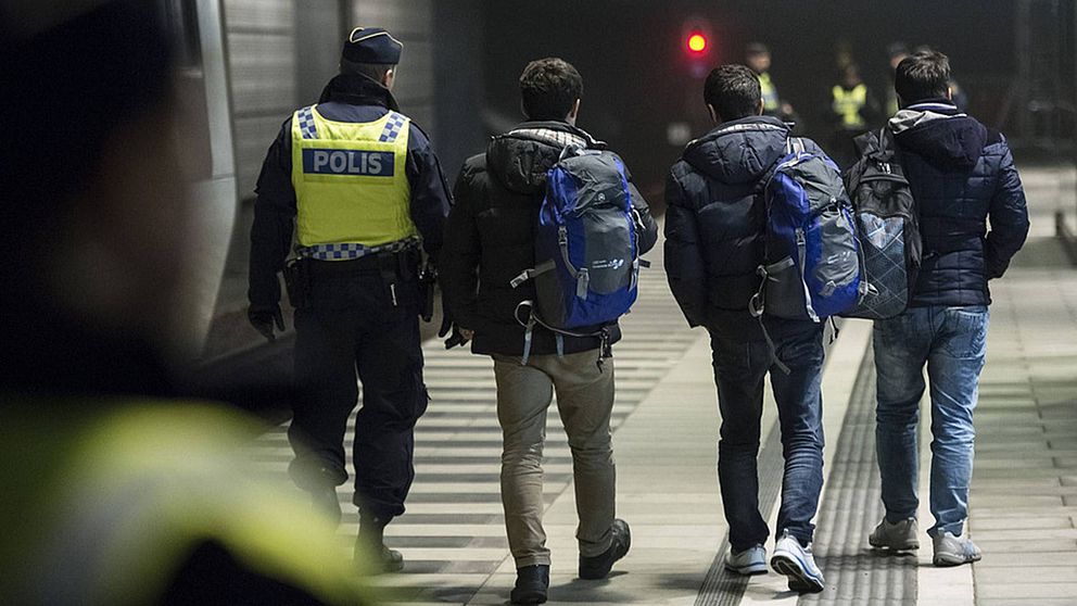 Polis eskorterar asylsökande från ett Öresundståg som stannat vid Hyllie station utanför Malmö efter genomförd gränskontroll.