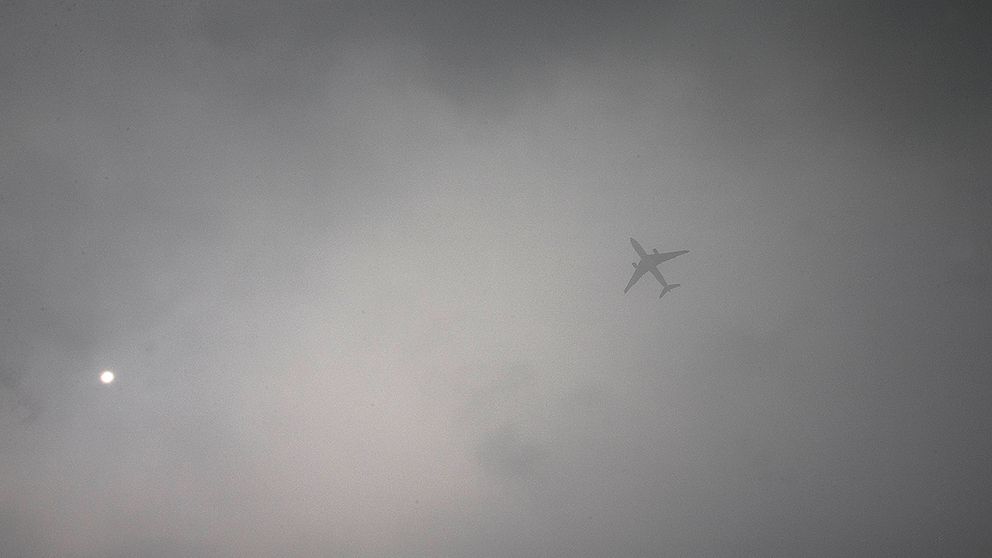 Ett passagerarplan flyger genom dimman i Peking.