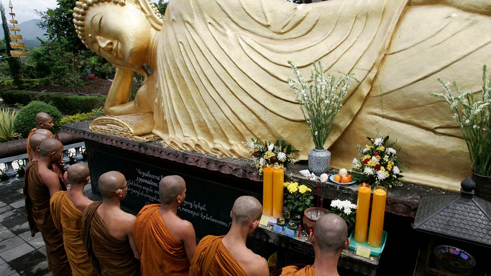 Munkar ber vid en Buddha-staty i Batu på östra Java. Indonesien är världens största muslimska land, men har också betydande religiösa minoriteter som kristna, hinduer och buddhister. Arkivbild.