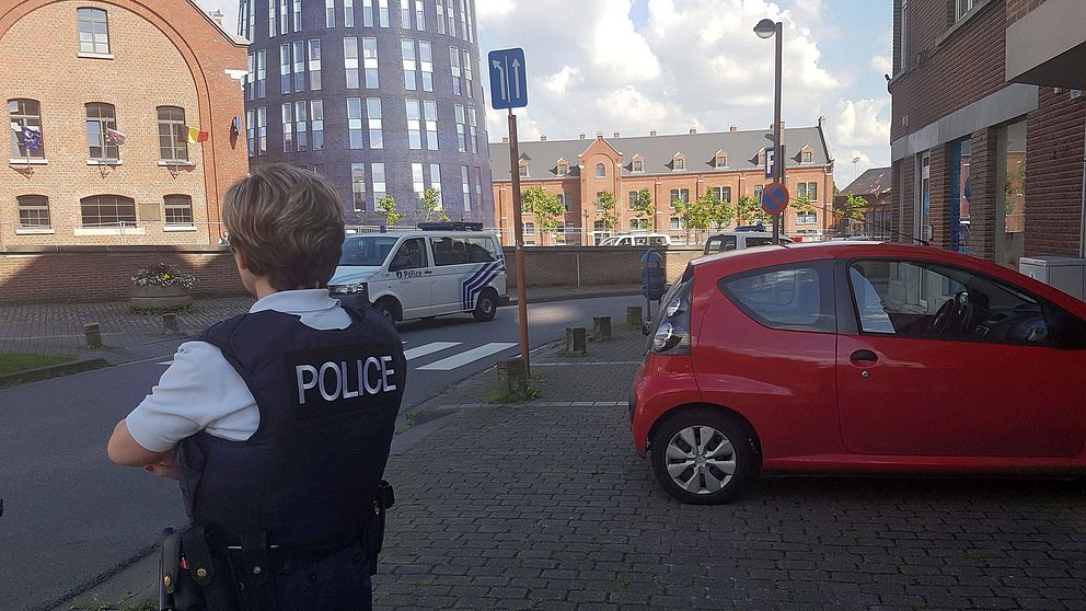 En belgisk polis utanför den polisstation där attacken inträffade.